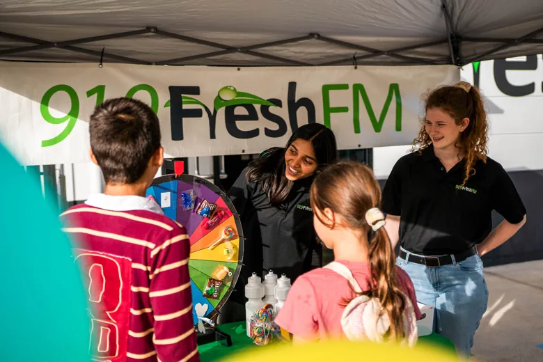 Fresh FM volunteers greeting children at a community event